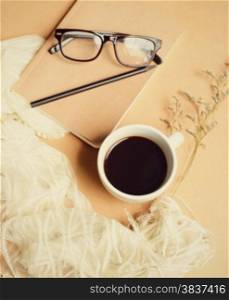 Notebook and eyeglasses with coffee, vintage filter effect