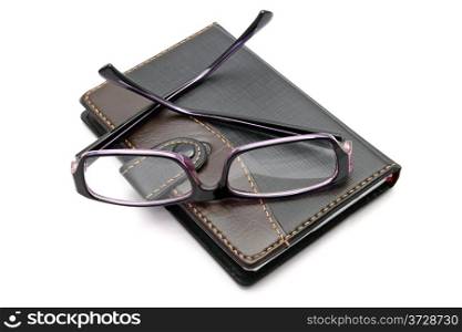 notebook and glasses isolated on white background