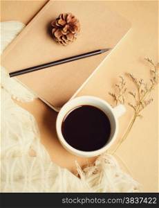 Notebook and hot coffee with vintage filter effect