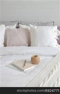 Notebook and knitting wool setting on bed in English country style bedding interior