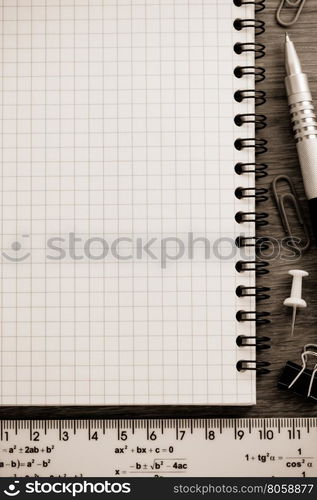 notebook and office accessories on wood background