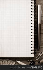 notebook and office accessories on wood background