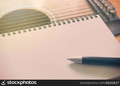 Notebook and pen on guitar,Writing music retro effect image