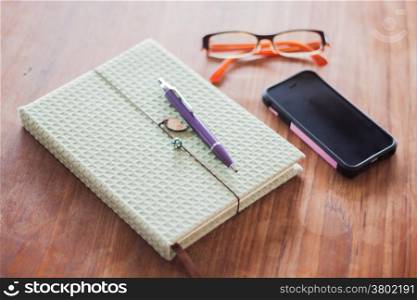 Notebook and pen on wooden table, stock photo