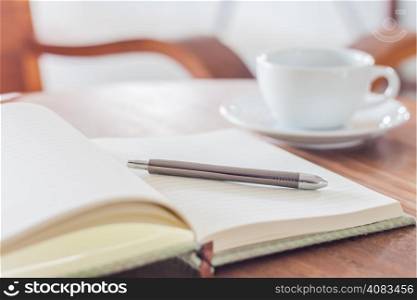 Notebook and pen with coffee cup, stock photo