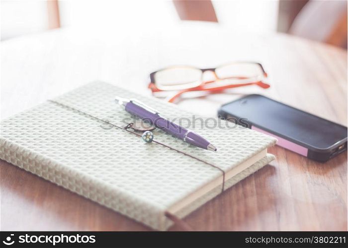 Notebook and smartphone on wooden table, stock photo