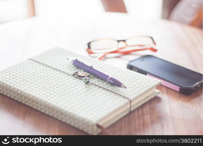 Notebook and smartphone on wooden table, stock photo