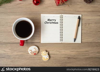 notebook, black coffee cup, Christmas cookies and pen on wood table, Top view and copy space. Xmas, Happy New Year, Goals, Resolution, To do list, Strategy and Plan concept