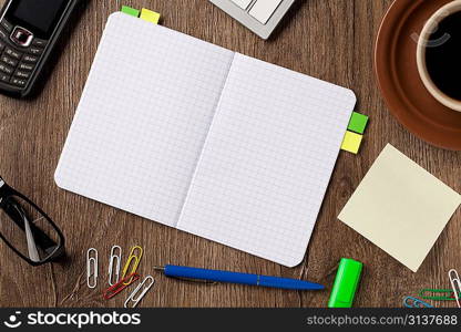 Notebook, coffee and office supplies on the deck.