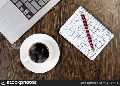 Notebook cup of coffee and notepad at table. Work place