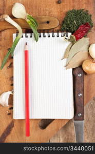 notebook for cooking recipes and spices on a wooden table