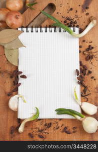 notebook for cooking recipes and spices on a wooden table