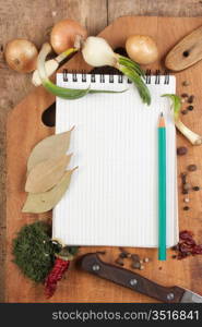 notebook for cooking recipes and spices on a wooden table