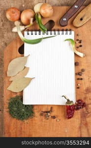 notebook for cooking recipes and spices on a wooden table