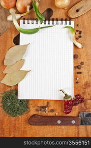 notebook for cooking recipes and spices on a wooden table