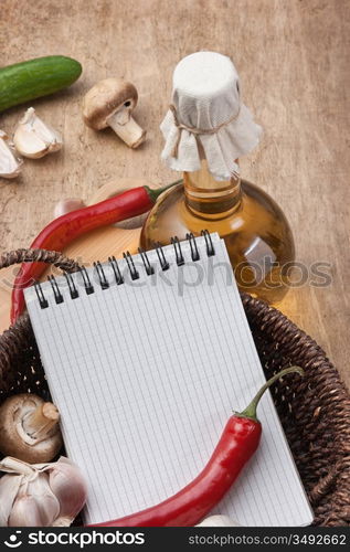 notebook for cooking recipes and vegetables on a cutting board