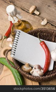 notebook for cooking recipes and vegetables on a cutting board