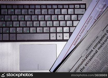 Notebook keyboard with a newspaper on it