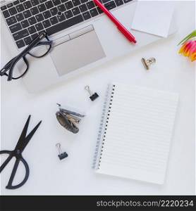 notebook laptop near stationery white desk