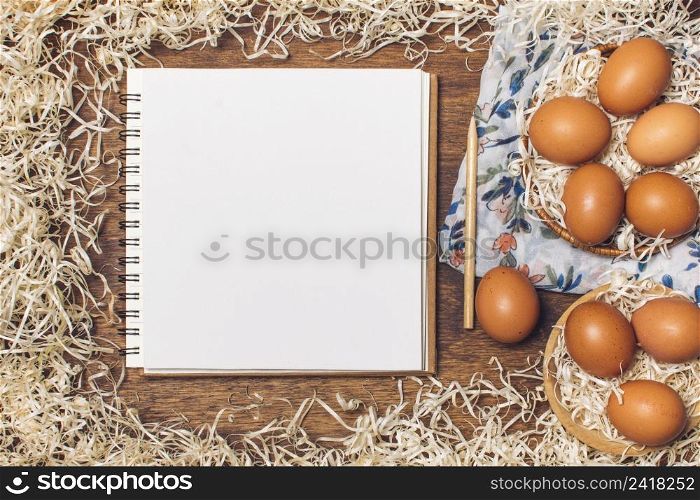 notebook near chicken eggs bowls flowered material tinsel board