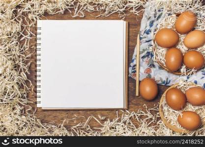 notebook near chicken eggs bowls flowered material tinsel board
