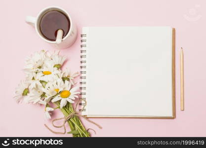 notebook near flowers cup drink