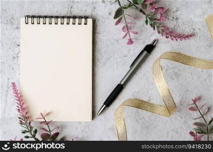 notebook, pen and flower is placed on white background