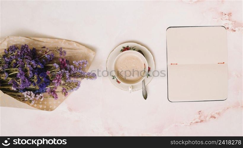 notebook with coffee cup flowers bouquet table
