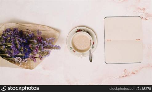 notebook with coffee cup flowers bouquet table