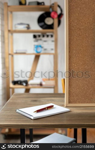 Notebook with pen and cork board frame background at table in office. Student home workplace