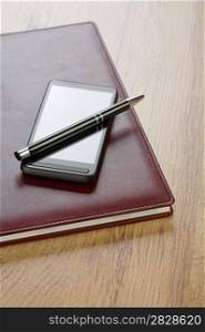 notebook with pen and mobile phone
