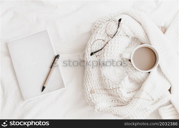 notebook with pen it near sweater with things bedsheet