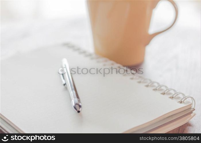 Notebook with pen on wooden table, stock photo
