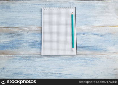 notebook with pen or pencil on a blue and white shabby vintage wooden background. the view from the top. Flat lay