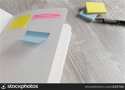 notebook with square sticky on wood background