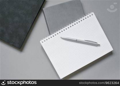 Notebooks or diaries with a blank page and a ballpoint pen on top of them. Office worker’s place