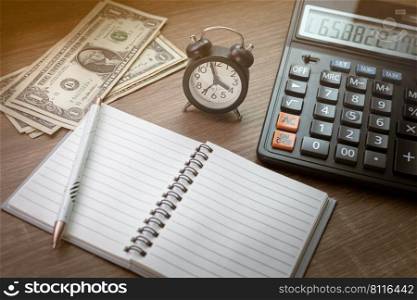 Notebooks, pens, watches and calculators on the wooden desk computational elements business finance time expenses