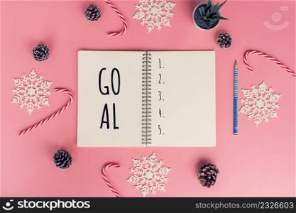 Notebooks with empty goals and phone on color background