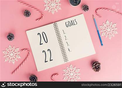 Notebooks with empty goals for 2022 year and christmas decorations on color background
