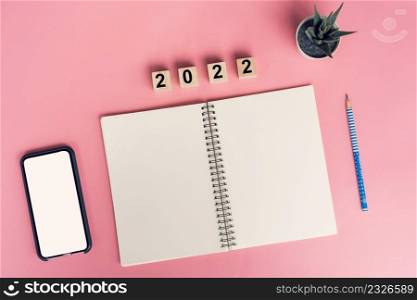 Notebooks with empty goals for 2022 year and phone on color background