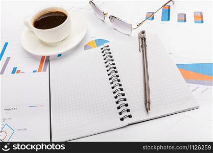 Notepad, a pen, coffee and glasses in business or school concept.