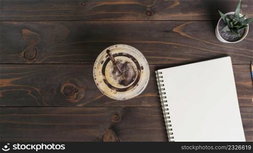 notepad and coffee cup on wooden table with copy space
