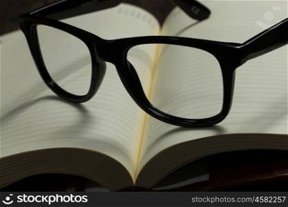 Notepad and glasses. Eye glasses lying on opened blank notepad