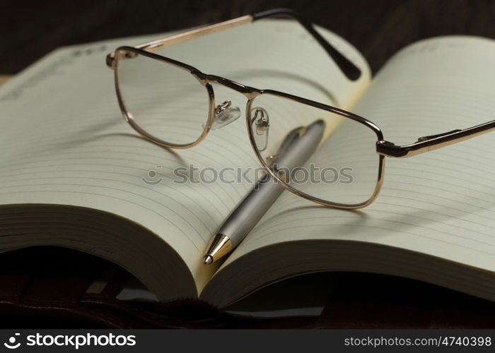 Notepad and glasses. Eye glasses lying on opened blank notepad