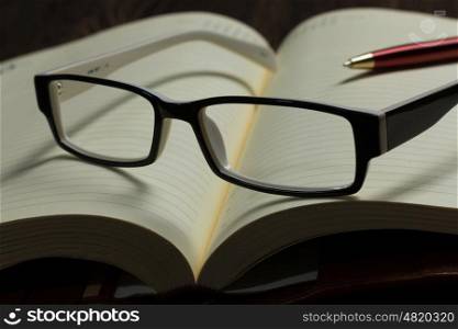 Notepad and glasses. Eye glasses lying on opened blank notepad