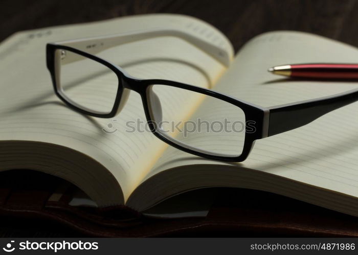 Notepad and glasses. Eye glasses lying on opened blank notepad