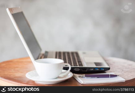 Notepad, laptop and coffee cup on wood table, stock photo