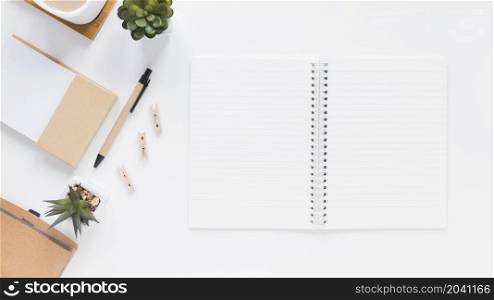 notepad near stationery flower pots white table