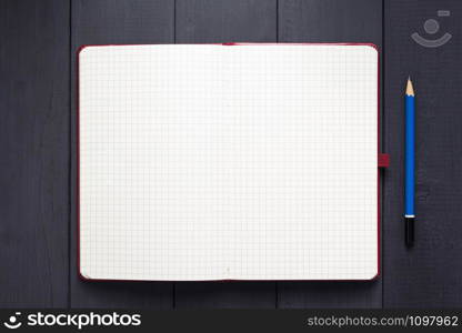 notepad or notebook paper at black wooden background surface table, top view