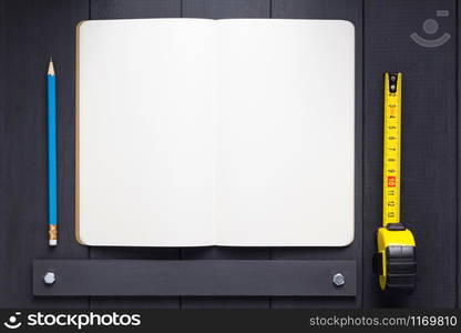 notepad or notebook paper at black wooden background surface table, top view